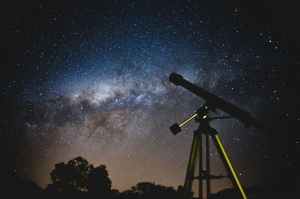 telescope aimed at a starry sky and the milky way