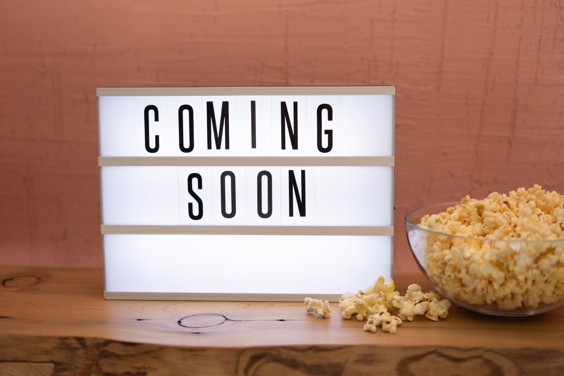 coming soon sign with popcorn in a glass bowl